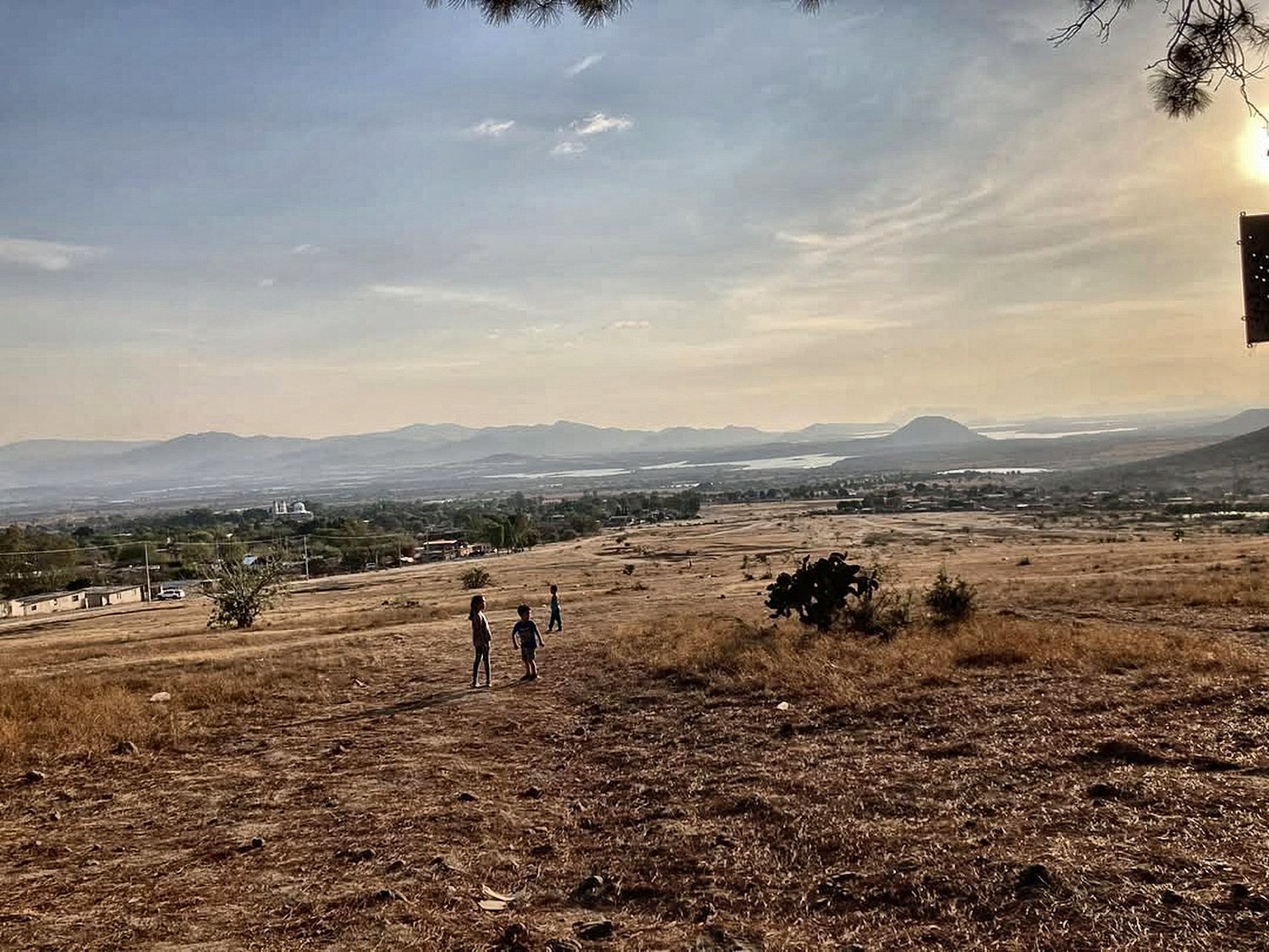 Atardecer sobre Puruagua, Guanajuato, visto desde el cerro: el pueblo, el templo, el valle y el agua a lo lejos