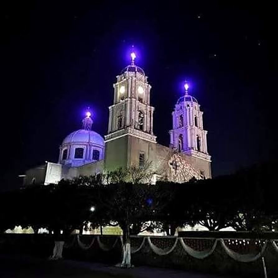El templo de San José Obrero de Puruagua iluminado de noche durante las fiestas